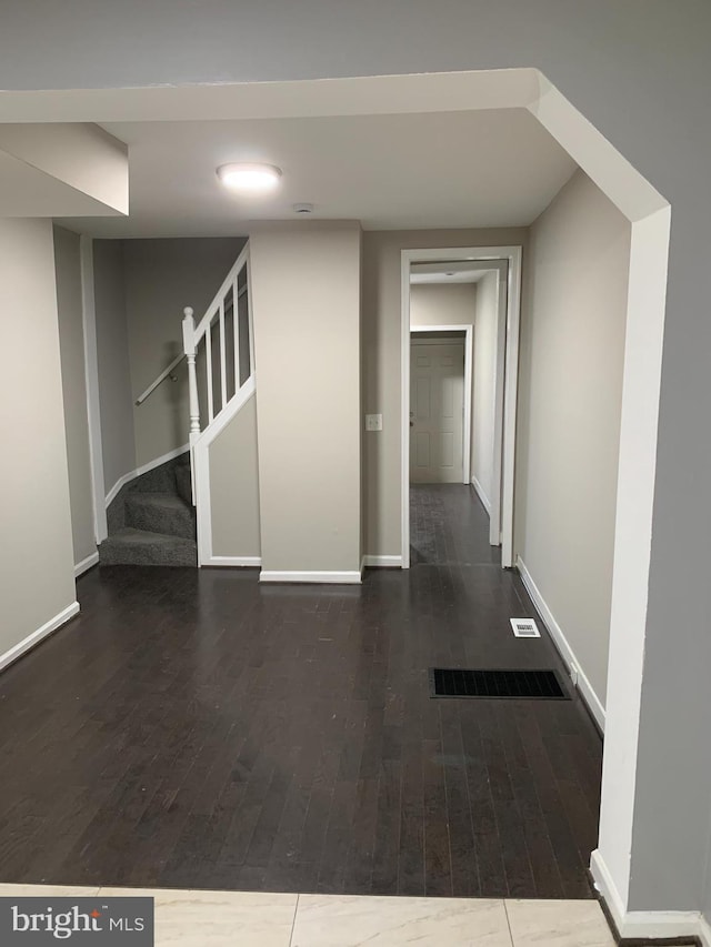 corridor with dark hardwood / wood-style flooring