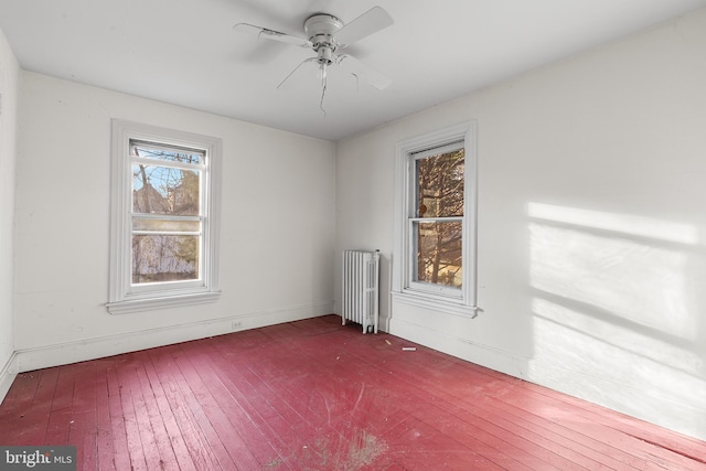 unfurnished room featuring ceiling fan and radiator