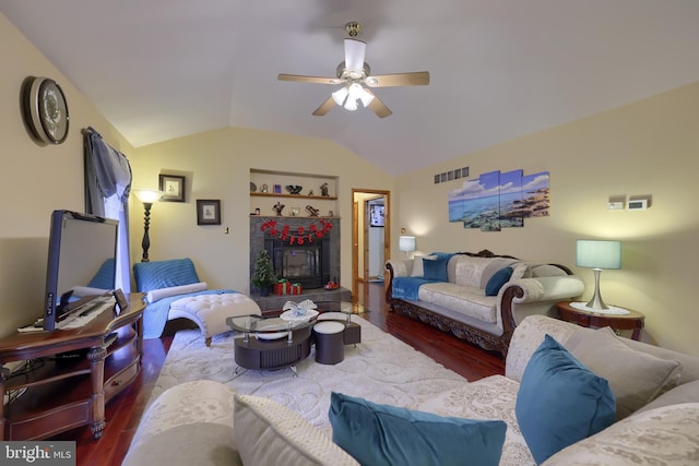 living room with built in shelves, ceiling fan, a tile fireplace, lofted ceiling, and hardwood / wood-style flooring