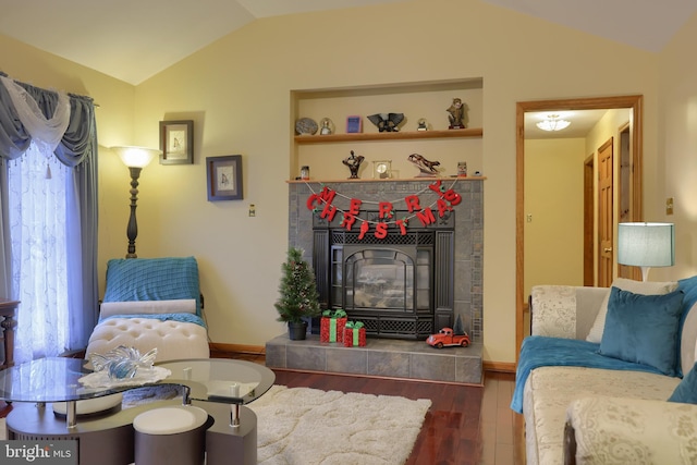 living room featuring a tiled fireplace, lofted ceiling, and dark hardwood / wood-style floors