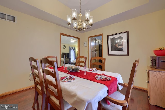 dining space featuring dark hardwood / wood-style floors and a notable chandelier