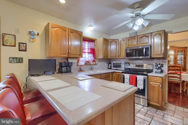 kitchen with tasteful backsplash, kitchen peninsula, sink, and stainless steel appliances