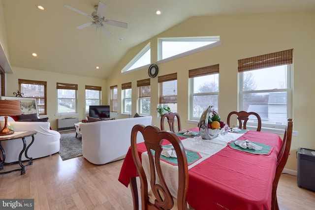 dining room with light hardwood / wood-style floors, vaulted ceiling, and ceiling fan