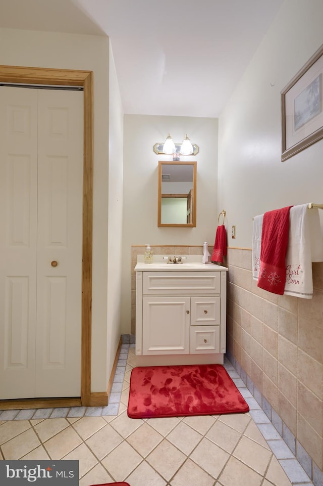 bathroom with tile patterned flooring, vanity, and tile walls