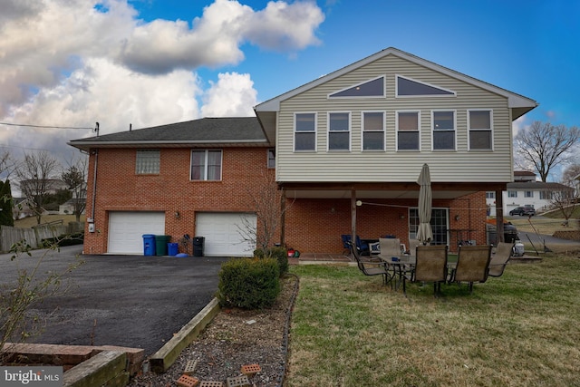 rear view of property featuring a lawn and a garage