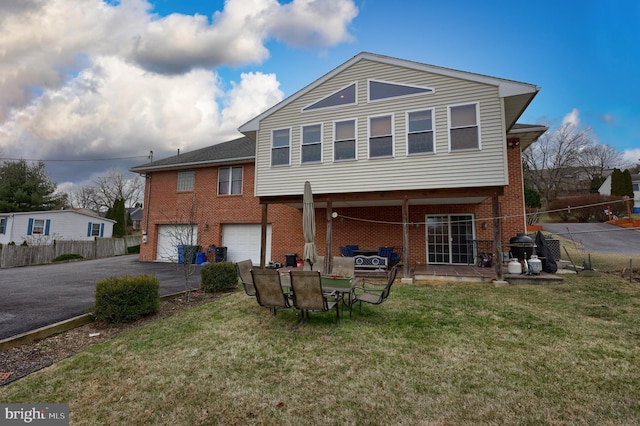 back of property featuring a yard and a garage