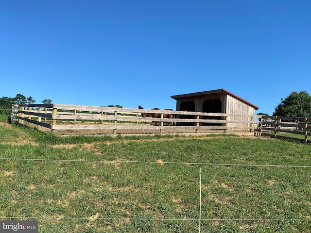 view of yard with a rural view and an outbuilding