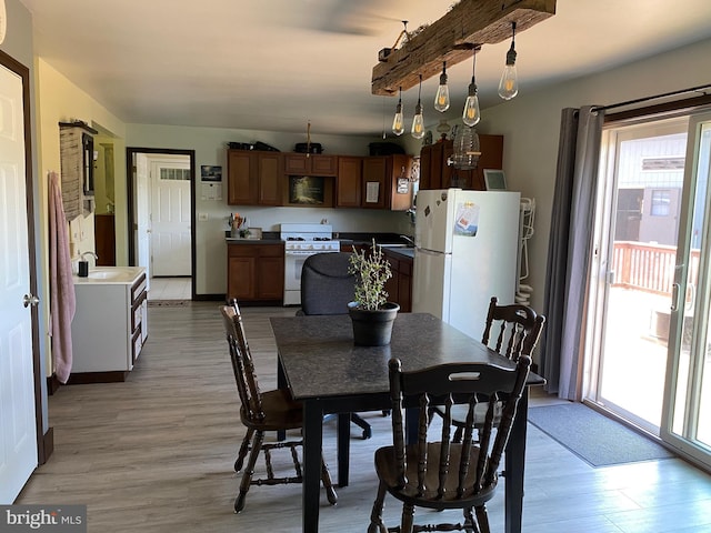 dining area with light hardwood / wood-style floors and sink