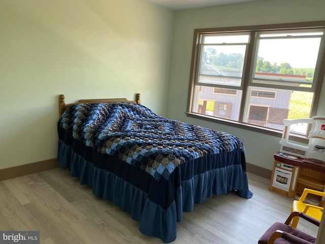 bedroom with hardwood / wood-style floors and multiple windows