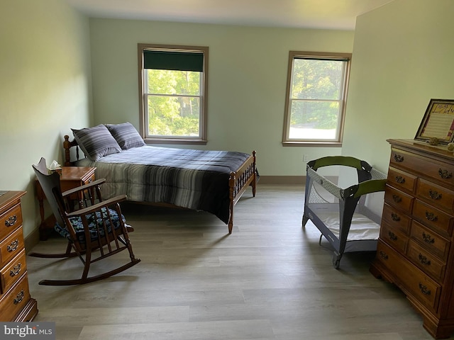 bedroom with light hardwood / wood-style floors and multiple windows