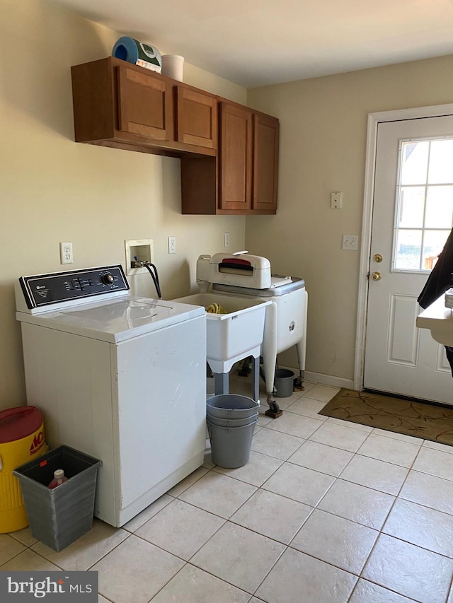 laundry room featuring cabinets, light tile patterned floors, and washing machine and dryer