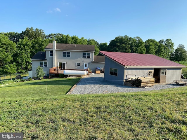 back of property with a deck and a yard