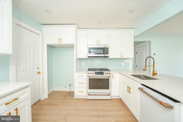 kitchen featuring white cabinetry, sink, light hardwood / wood-style flooring, white appliances, and decorative backsplash