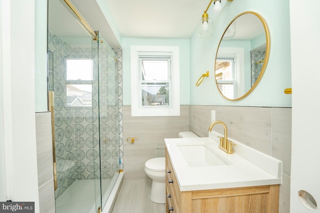 bathroom featuring an enclosed shower, vanity, toilet, and tile walls