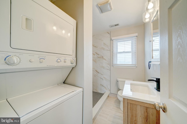 clothes washing area with sink and stacked washer and clothes dryer