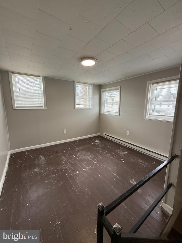 basement featuring a baseboard radiator and dark hardwood / wood-style floors