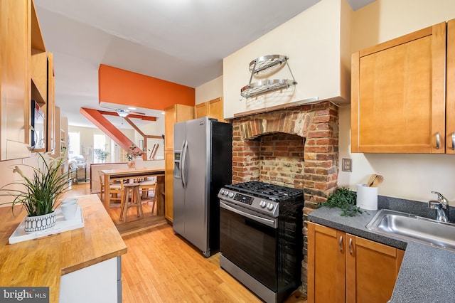 kitchen featuring ceiling fan, sink, light hardwood / wood-style flooring, and appliances with stainless steel finishes