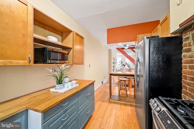 kitchen featuring wooden counters, ceiling fan, gray cabinets, light wood-type flooring, and appliances with stainless steel finishes