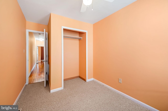 unfurnished bedroom featuring ceiling fan, light colored carpet, and a closet