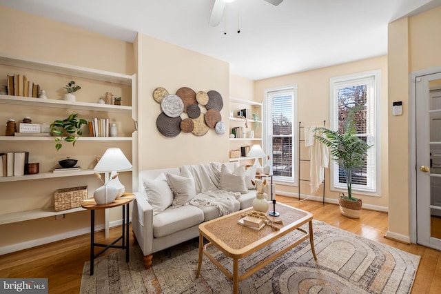 living room with light hardwood / wood-style flooring and ceiling fan