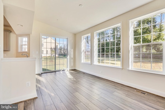 unfurnished sunroom featuring lofted ceiling