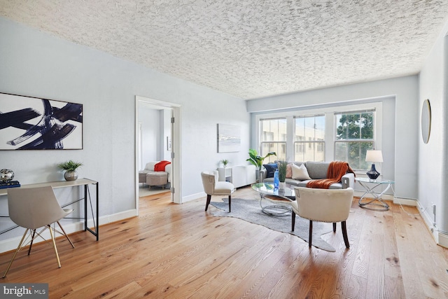 living room with light hardwood / wood-style floors and a textured ceiling