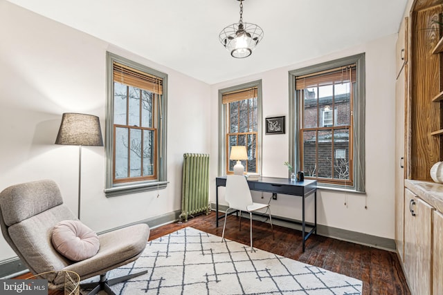 office area featuring dark hardwood / wood-style floors, radiator heating unit, and an inviting chandelier