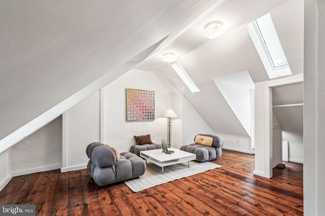 sitting room with dark wood-type flooring and vaulted ceiling with skylight