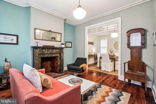 living room featuring dark hardwood / wood-style flooring, ornamental molding, and a premium fireplace