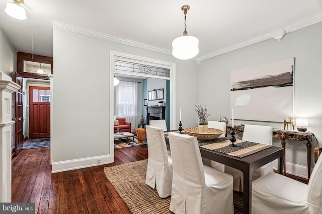 dining space featuring dark wood-type flooring and ornamental molding