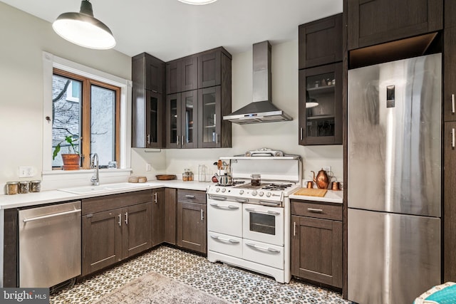 kitchen featuring appliances with stainless steel finishes, sink, dark brown cabinetry, and wall chimney exhaust hood