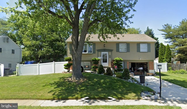 split foyer home with a front lawn and a garage