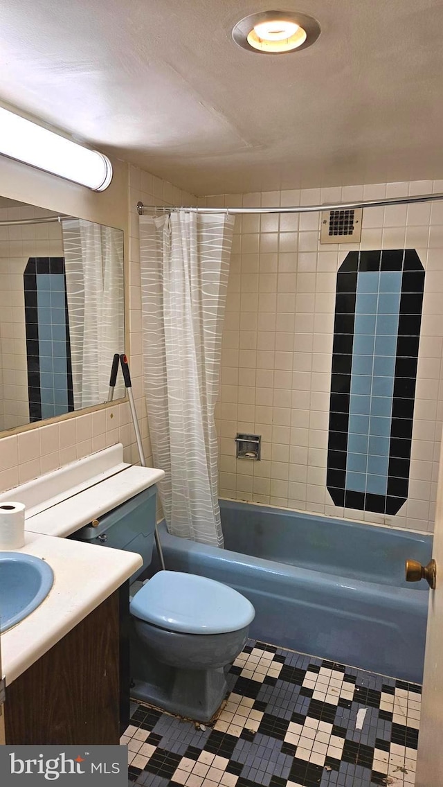 full bathroom with toilet, tile walls, vanity, shower / bath combination with curtain, and tile patterned flooring