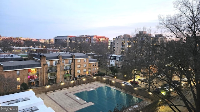 pool at dusk featuring a patio