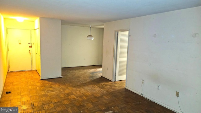 spare room featuring dark parquet flooring