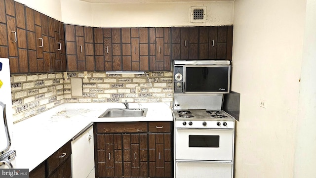 kitchen with white appliances, sink, and dark brown cabinets