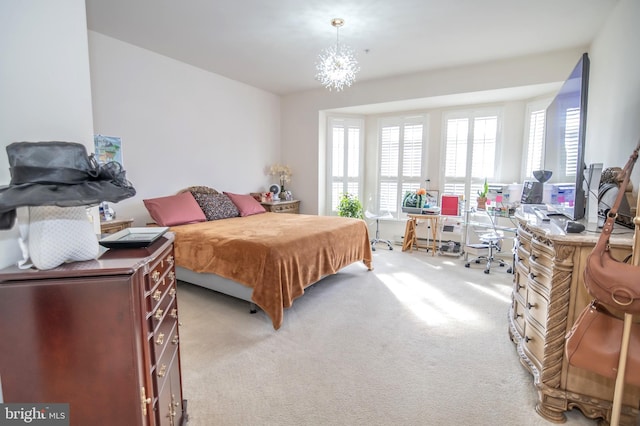 bedroom featuring a notable chandelier and light colored carpet