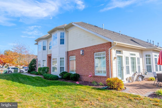 view of side of home featuring a yard and a patio