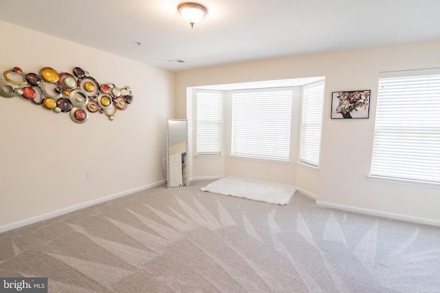 carpeted spare room featuring plenty of natural light