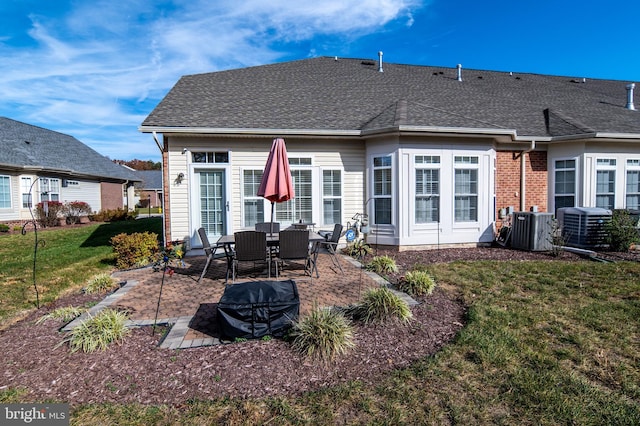 rear view of house with a yard, a patio area, and central air condition unit