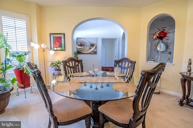 dining space featuring light carpet