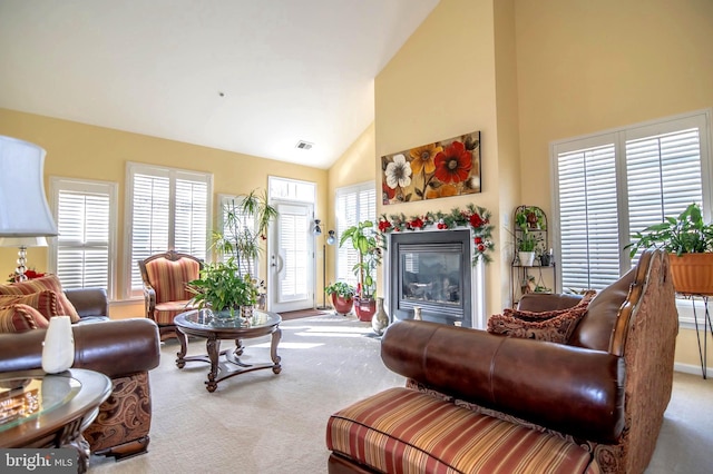 carpeted living room with high vaulted ceiling