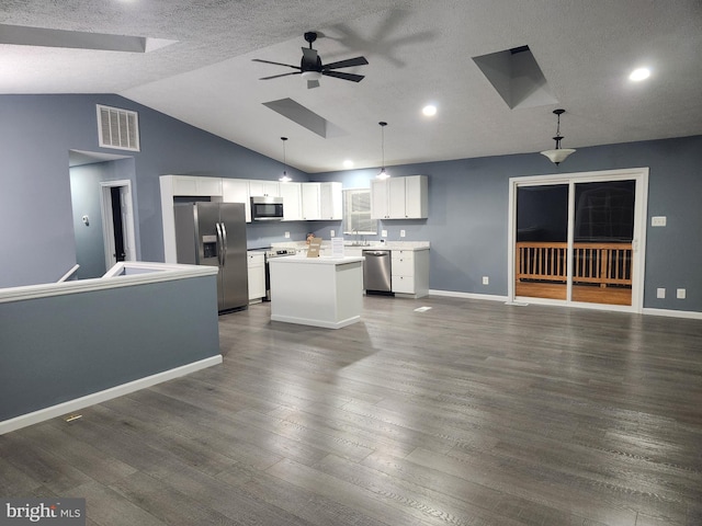 kitchen featuring white cabinetry, stainless steel appliances, pendant lighting, vaulted ceiling, and a kitchen island