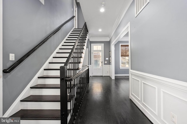 foyer entrance featuring crown molding and dark wood-type flooring