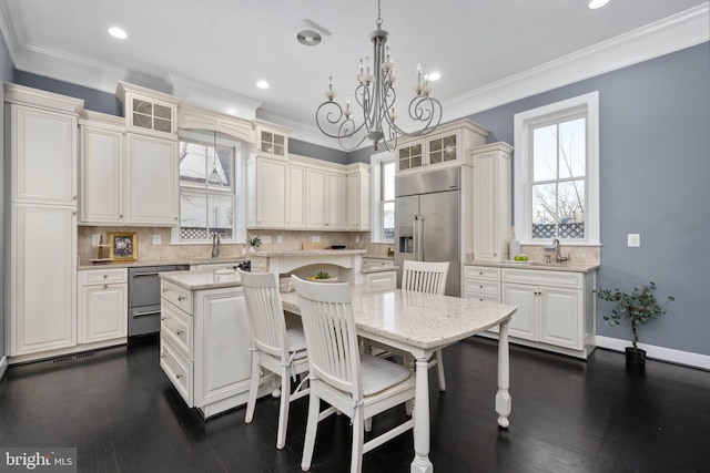 kitchen featuring appliances with stainless steel finishes, tasteful backsplash, a kitchen island, and hanging light fixtures