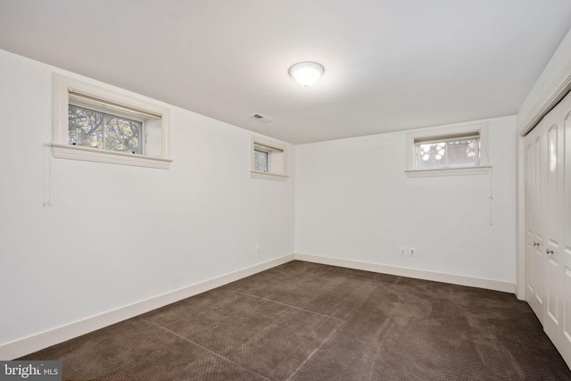 basement featuring dark colored carpet