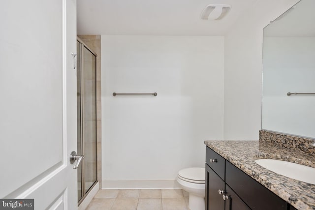 bathroom with tile patterned floors, vanity, a shower with shower door, and toilet