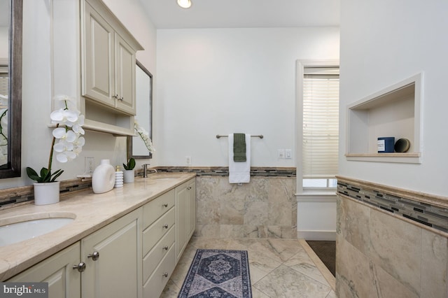 bathroom featuring vanity and tile walls