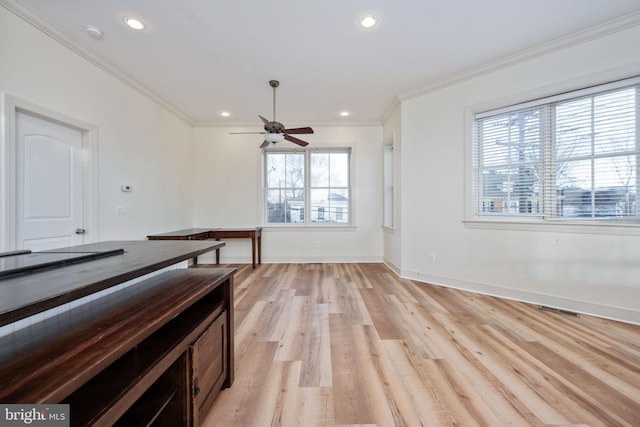 interior space with ceiling fan, light hardwood / wood-style flooring, a healthy amount of sunlight, and ornamental molding