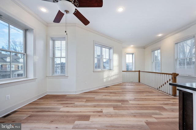 unfurnished room with ceiling fan, light hardwood / wood-style flooring, and crown molding